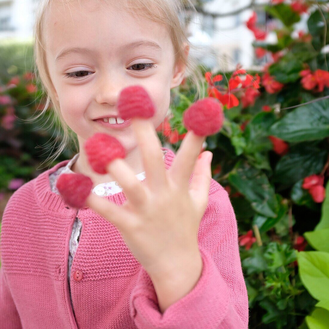 France, Val de Marne, Charenton le Pont, girl playing with raspberries