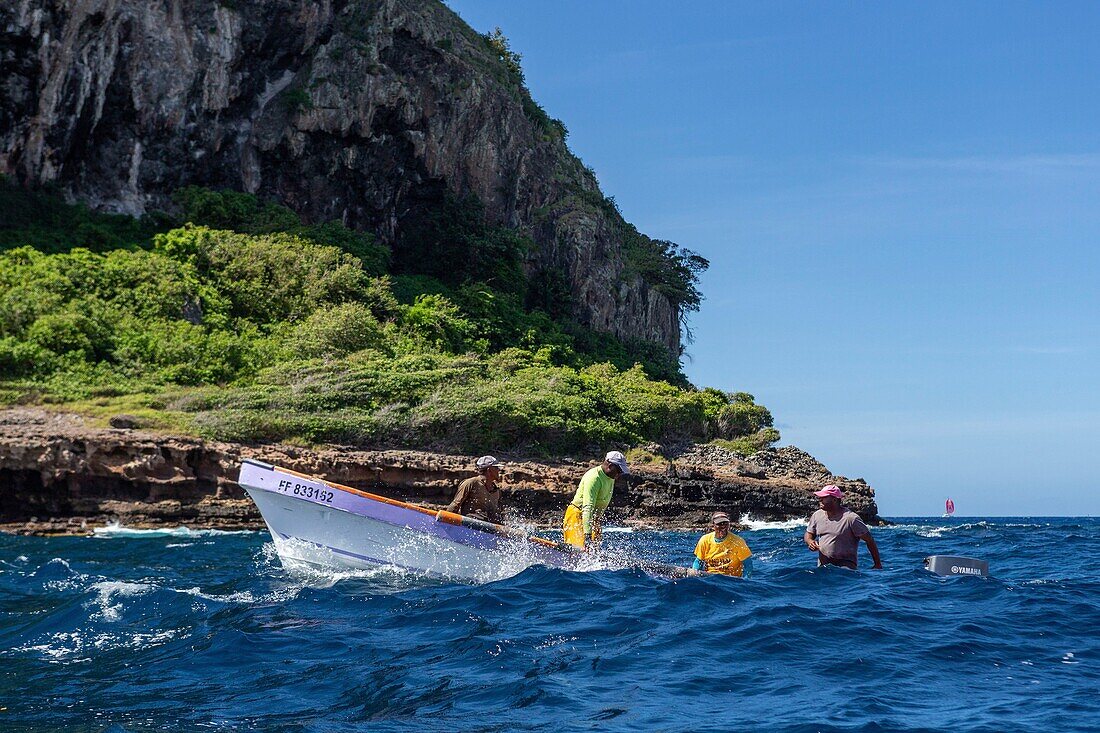 Martinique, below the rock of the diamond a yole motorboat typical of the Caribbean, with on board 4 fishermen