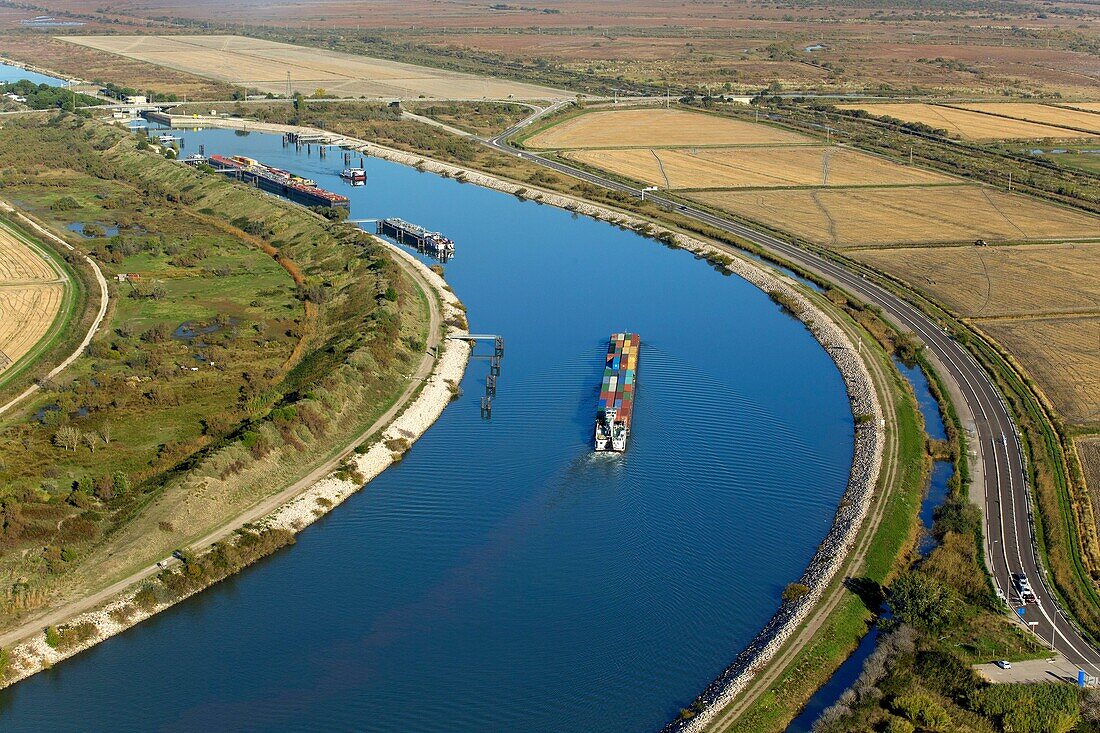 Frankreich, Bouches du Rhone, Port Saint Louis du Rhone, Einfahrt eines Containerkahns in die Schleuse Barcarin am Rhone-Schifffahrtskanal im Hafen von Fos sur Mer (Luftaufnahme)