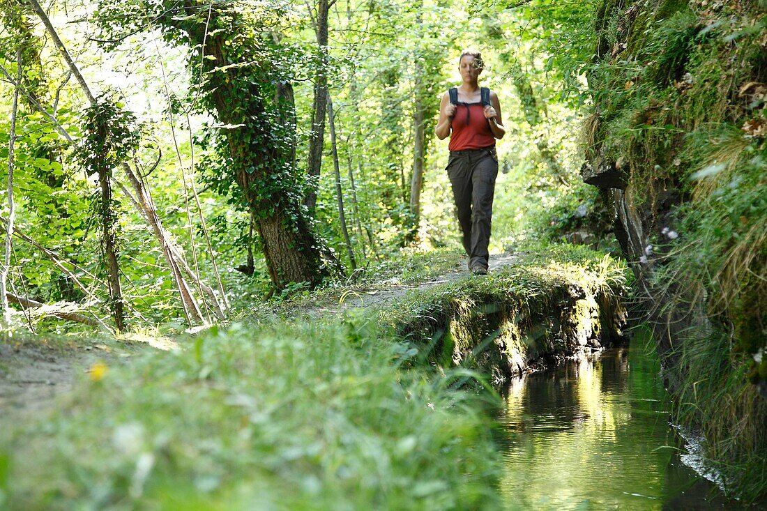 France, Isere, Valbonnais, Female hiker near the Moines canal next to Valbonnais village