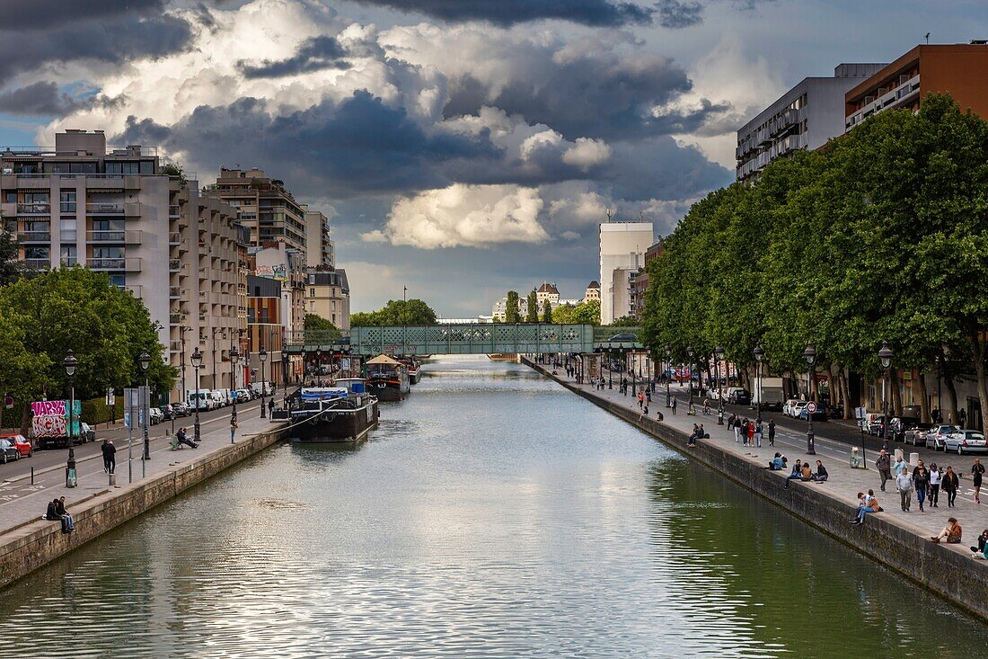 Frankreich, Paris, La Villette, Villette-Kanal, Blick auf die Straßenanimation der Quais des Kanals von La Villette unter einem Gewitterhimmel