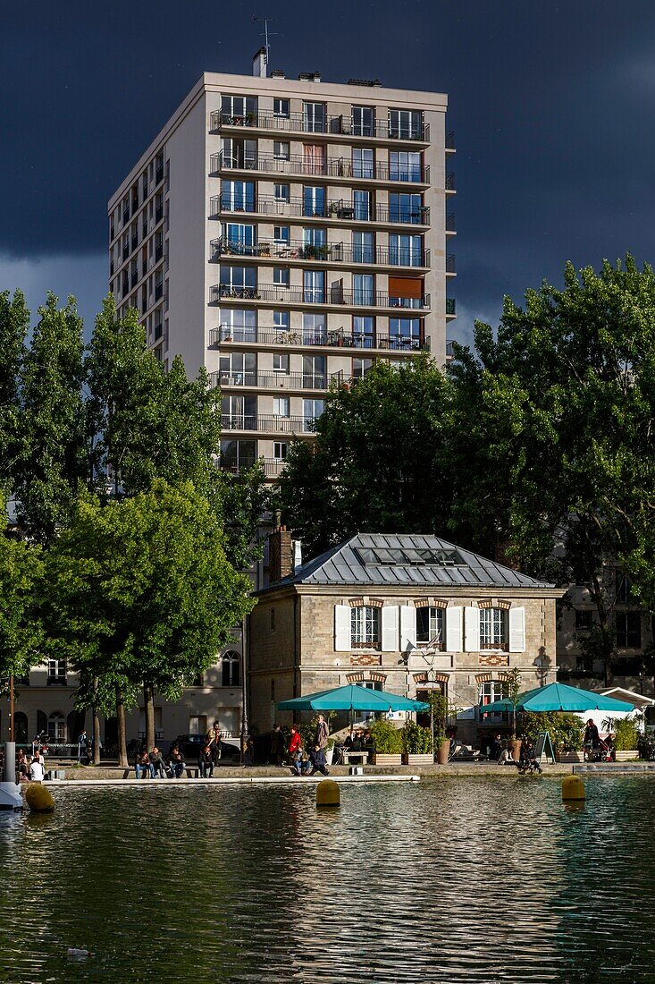 Frankreich, Paris, La Villette, Villette-Kanal, Blick auf die Straßenanimation der Kais des Kanals von La Villette unter einem Gewitterhimmel
