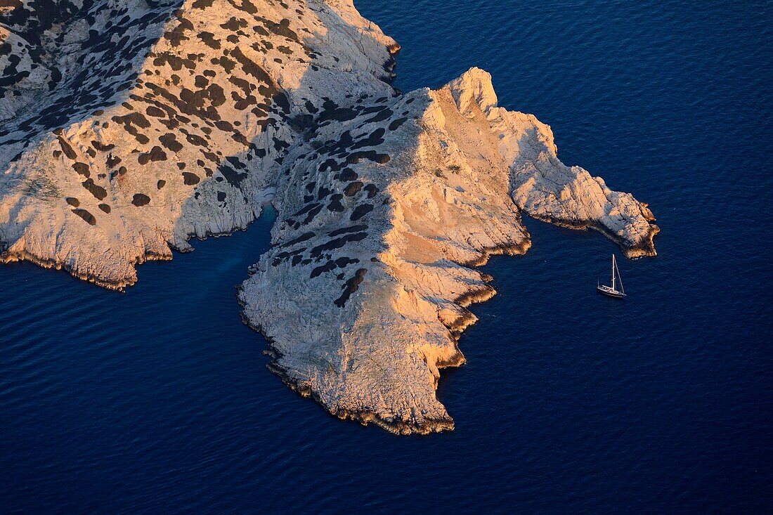 France, Bouches du Rhone, Calanques National Park, Marseille, Riou Archipelago Nature Reserve, Riou Island, Fontagne Point, sailboat in the Calanque de Boulegeade and Fontagne Cove (aerial view)