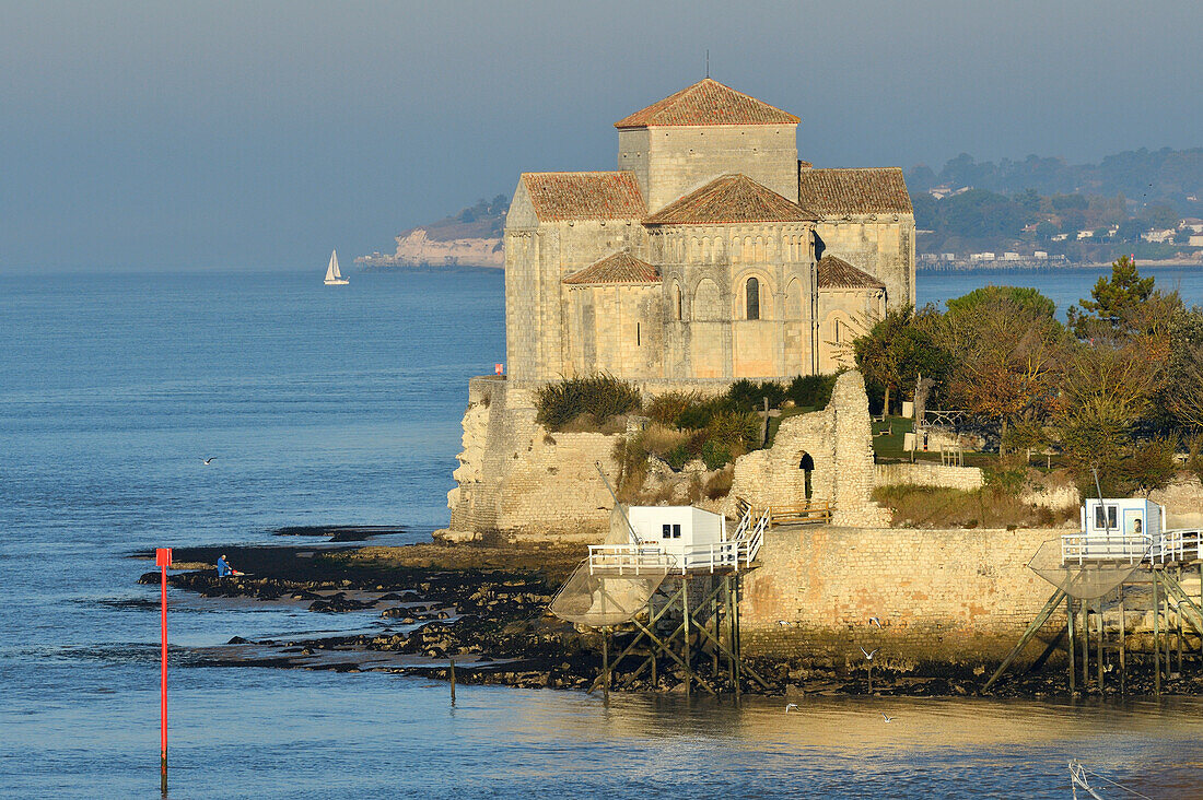 Frankreich, Charente Maritime, Saintonge, Mündung der Gironde, Saintonge, Talmont sur Gironde, ausgezeichnet als Les Plus Beaux Villages de France (Die schönsten Dörfer Frankreichs), Hütten auf Stelzen für Carrelet (Fischerhütte) Fischernetz und Sainte Radegonde Kirche in Saintonge romanischer Stil des 12.