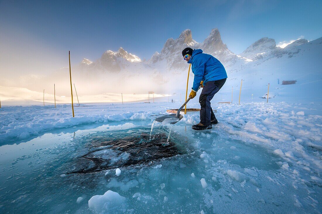 Frankreich, Isère (38), Belledonne, Chamrousse, Robert Lakes, während ein Team von Tauchern sich darauf vorbereitet, unter dem Eis zu tauchen, bereitet der Direktor des Dive Xtreme Clubs die Oberlichter vor, indem er das kühle Eis der Nacht bricht