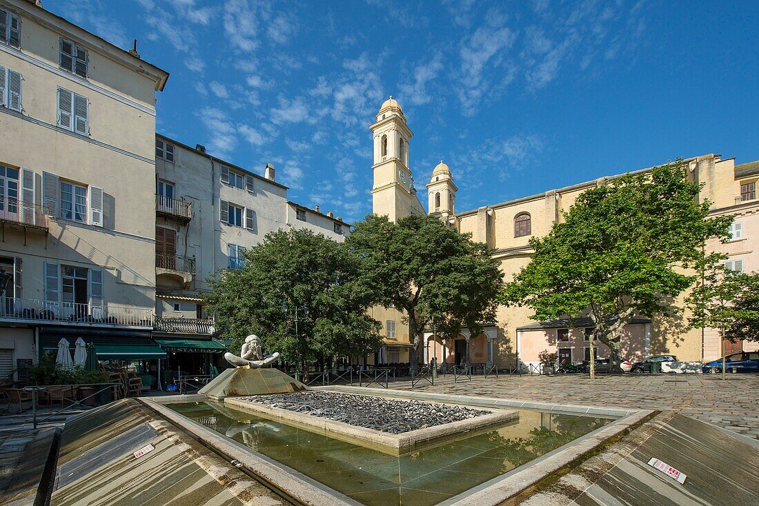 Frankreich, Haute Corse, Bastia, Kirche Saint Jean Baptiste vom Rathausplatz oder Marktplatz aus gesehen und moderner Brunnen