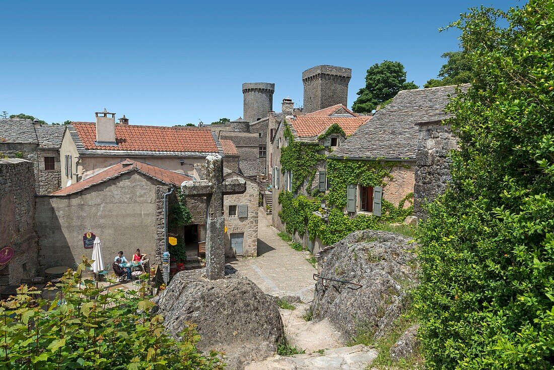 Frankreich, Aveyron, La Couvertoirade, beschriftet mit Les Plus Beaux Villages de France (Die schönsten Dörfer Frankreichs), dominanter Blick auf einen Dorfkern mit einem Steinkreuz im Vordergrund