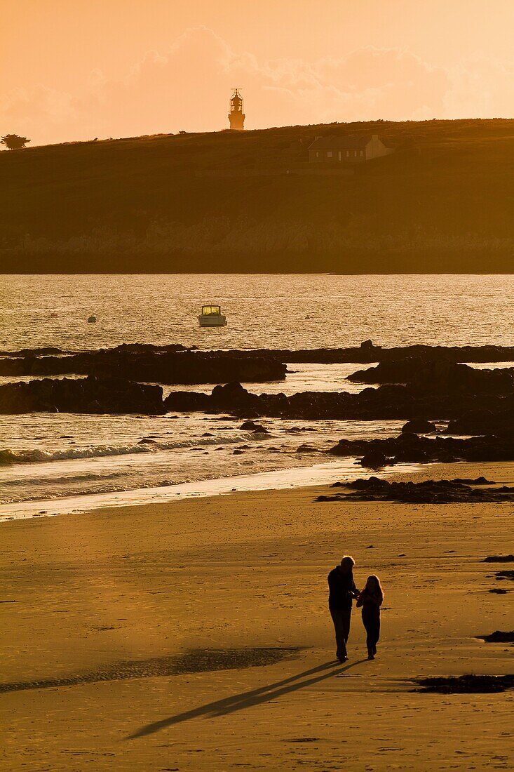 France, Finistere, Ponant islands, Armorica Regional Nature Park, Iroise Sea, Ouessant island, Biosphere Reserve (UNESCO), Walkers on Prat beach in the evening and Creac'h lighthouse in the background