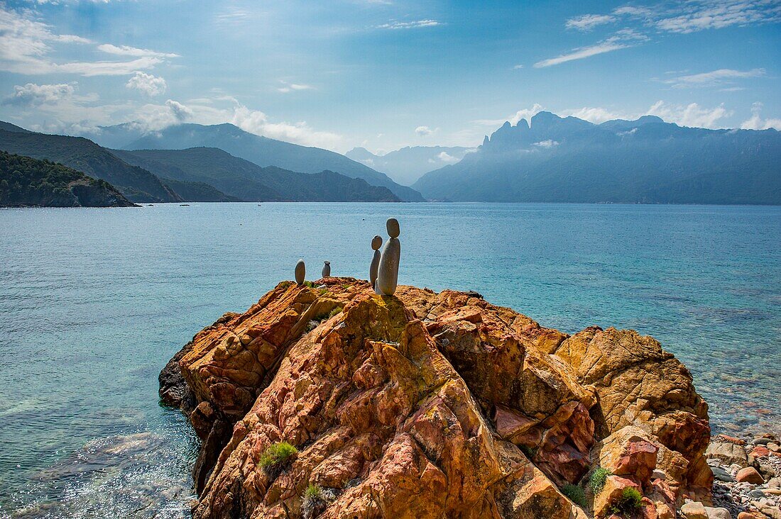 Frankreich, Corse du Sud, Porto, Golf von Porto, von der UNESCO zum Weltkulturerbe erklärt, am Strand Gradelle hat ein Künstler große graue Kieselsteine zu ephemeren Statuen aufgeschichtet, die sich von den ockerfarbenen Felsen abheben, ein Wunderwerk