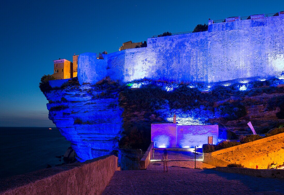 Frankreich, Corse du Sud, Bonifacio, Lichtspiel auf der Zitadelle und der Bastion des Etendard vom Fußweg der Klippen aus gesehen in der Abenddämmerung