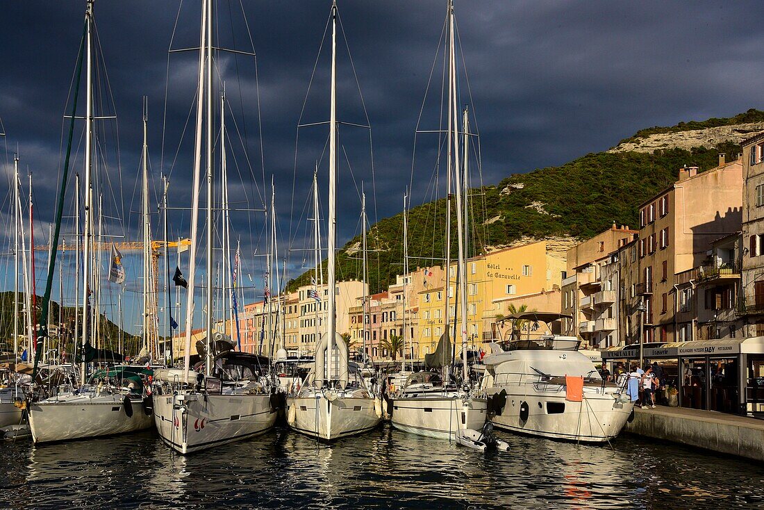 Frankreich, Corse du Sud, Bonifacio, Segelboote im Yachthafen bei Sonnenuntergang unter stürmischem Himmel