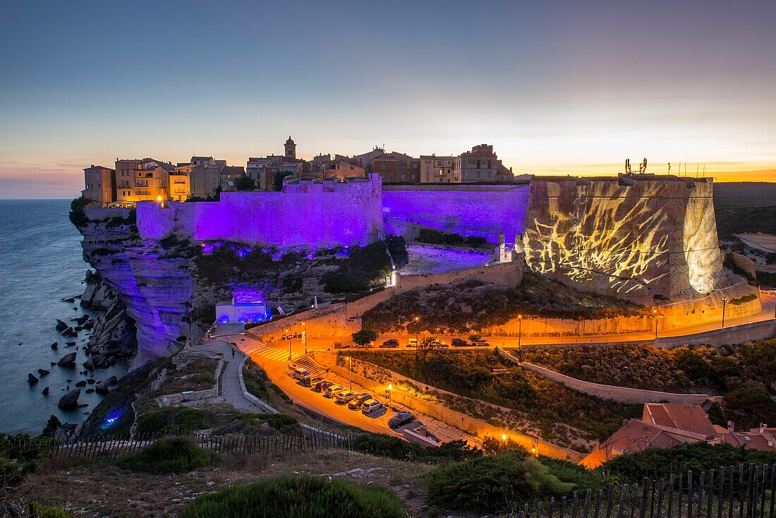 Frankreich, Corse du Sud, Bonifacio, Lichtspiel auf der Zitadelle und der Bastion des Etendard vom Fußweg der Klippen aus gesehen in der Abenddämmerung