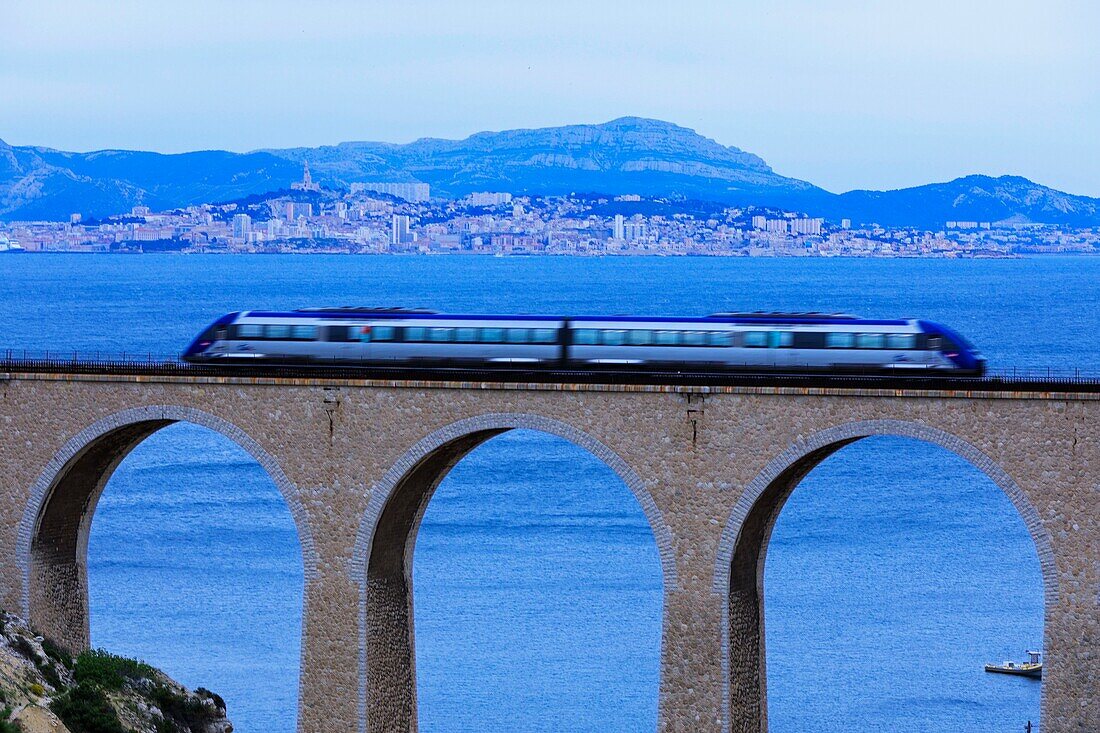 Frankreich, Bouches du Rhone, Die blaue Küste, Le Rove, Bucht von La Vesse, die Eisenbahnbrücke und der Zug von La Côte Bleue, Marseille im Hintergrund