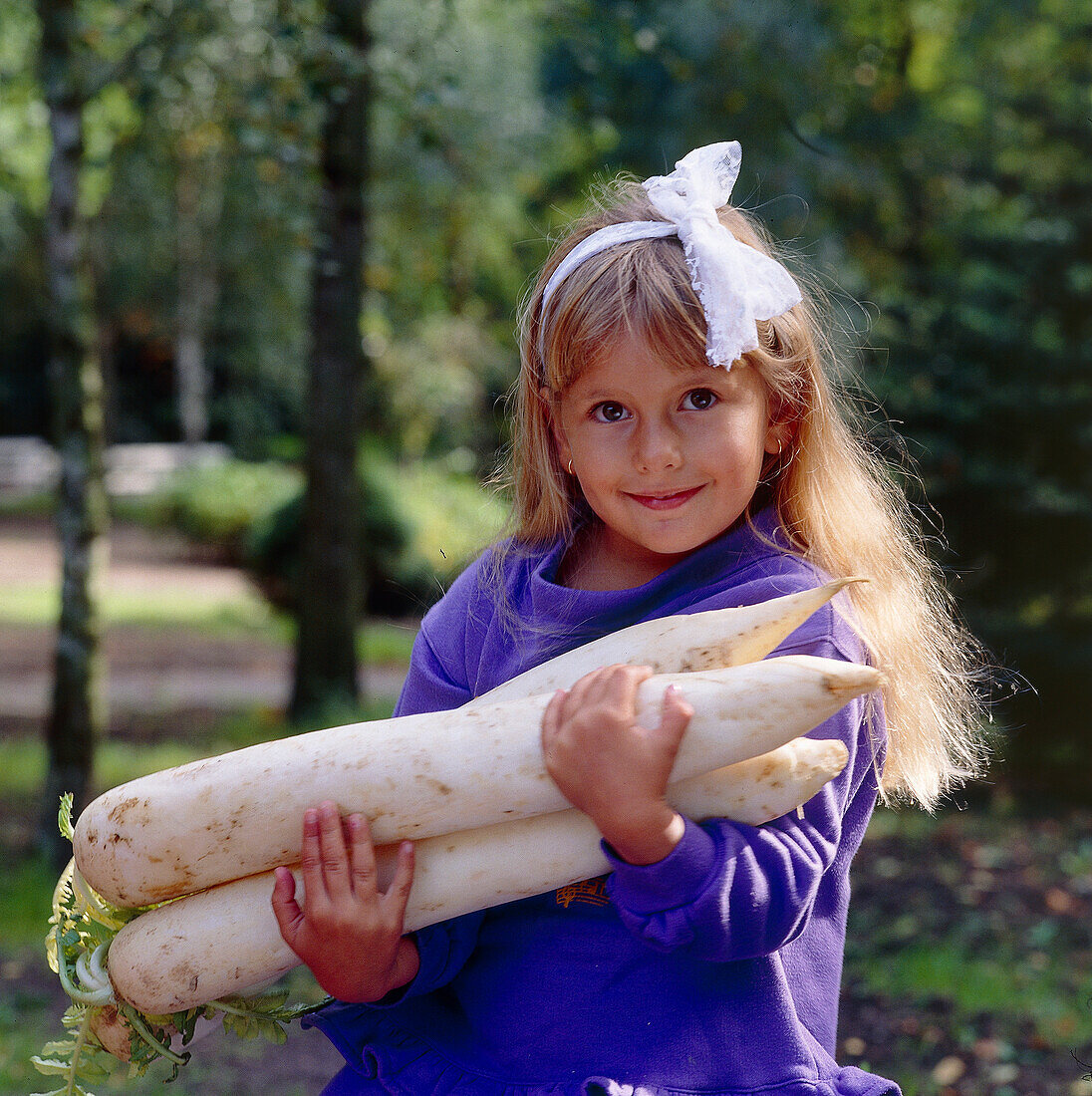 Girl holding large white radishes