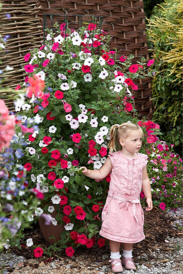 Girl in front of large petunia container