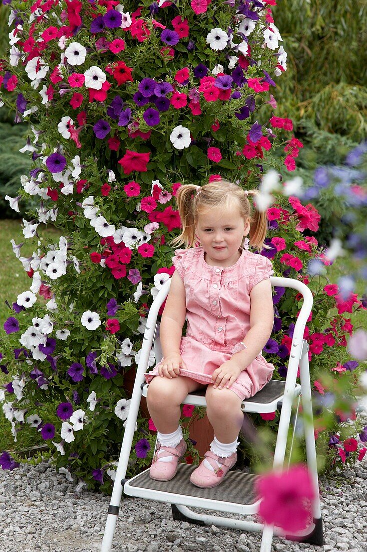 Girl in front of large petunia container