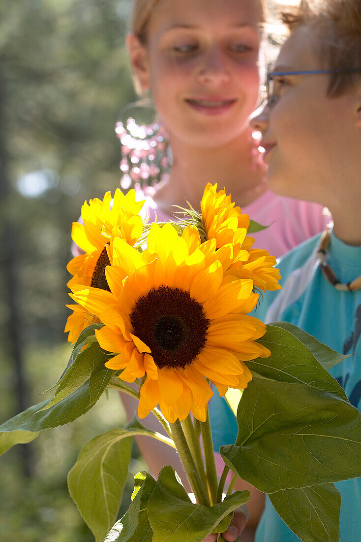 Zwei Teenager mit Sonnenblumen