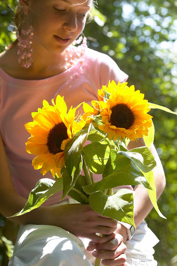 Mädchen mit Sonnenblumen in der Hand