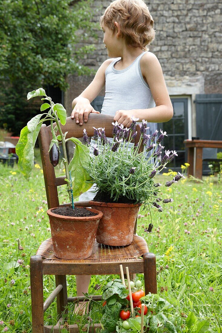 Boy standing by chair in garden