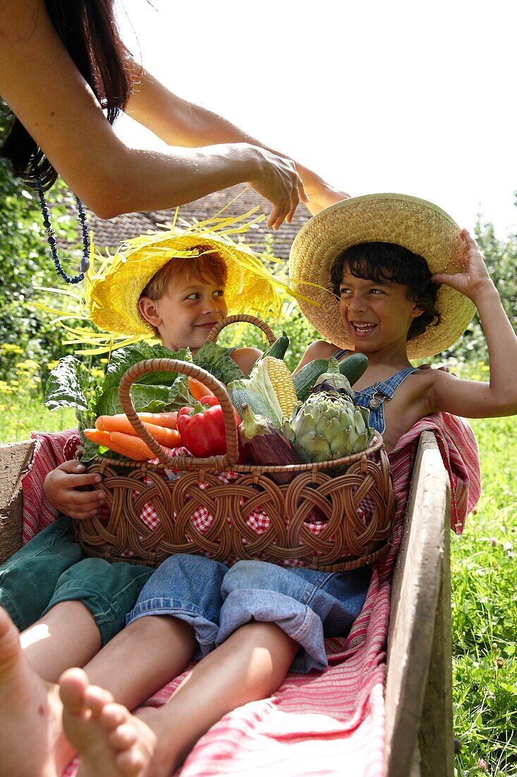 Children holding basket with vegetables