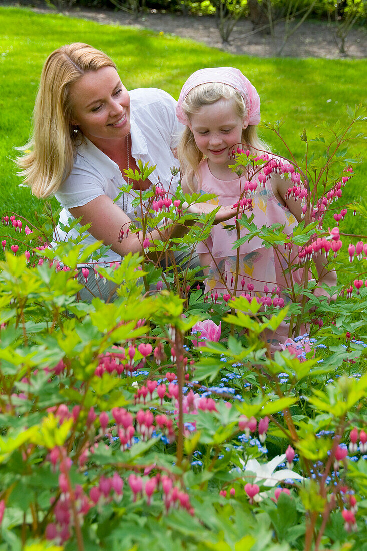 Frau und Kind mit Dicentra spectabilis