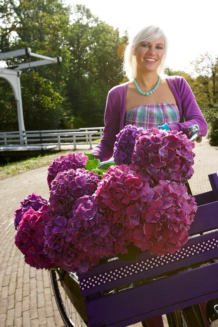 Frau mit Fahrrad und Blumen