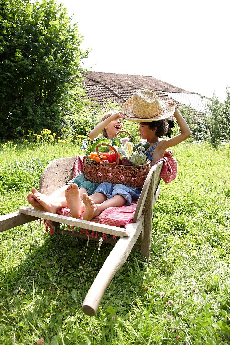 Children sitting in wheelbarrow