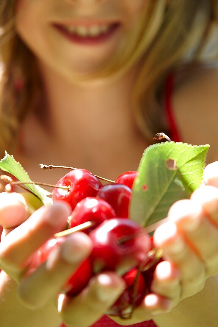 Girl holding cherries