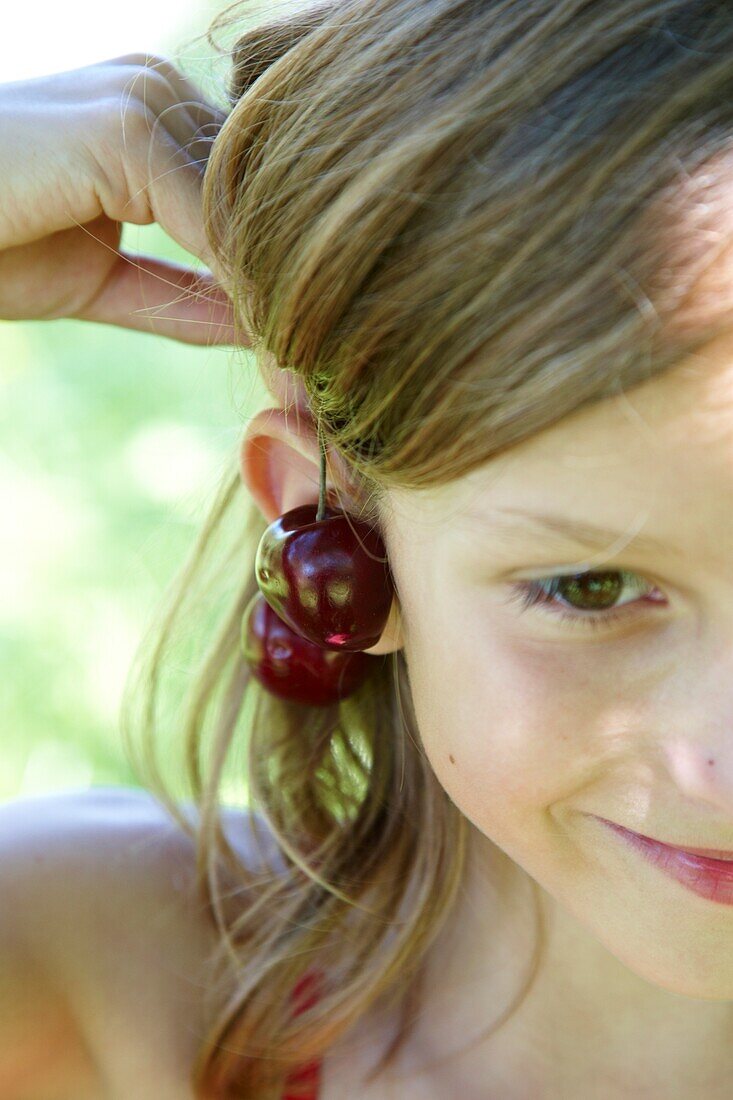 Girl holding cherries