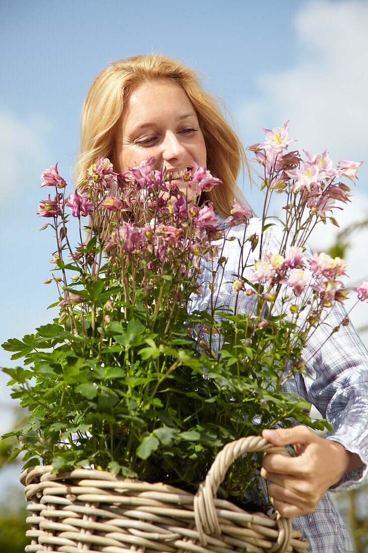 Woman holding basket of Aquilegia 