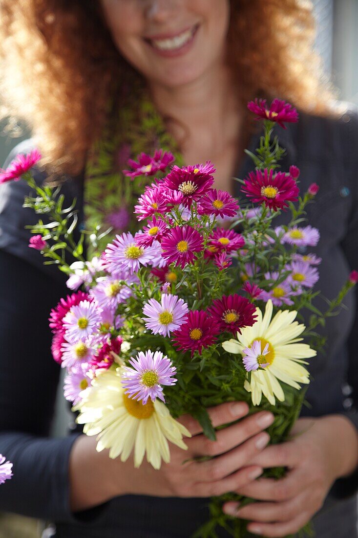 Frau hält Herbstblumen