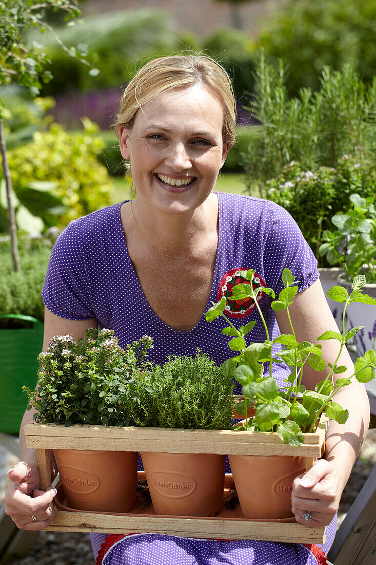 Frau bei der Gartenarbeit mit Kräutern