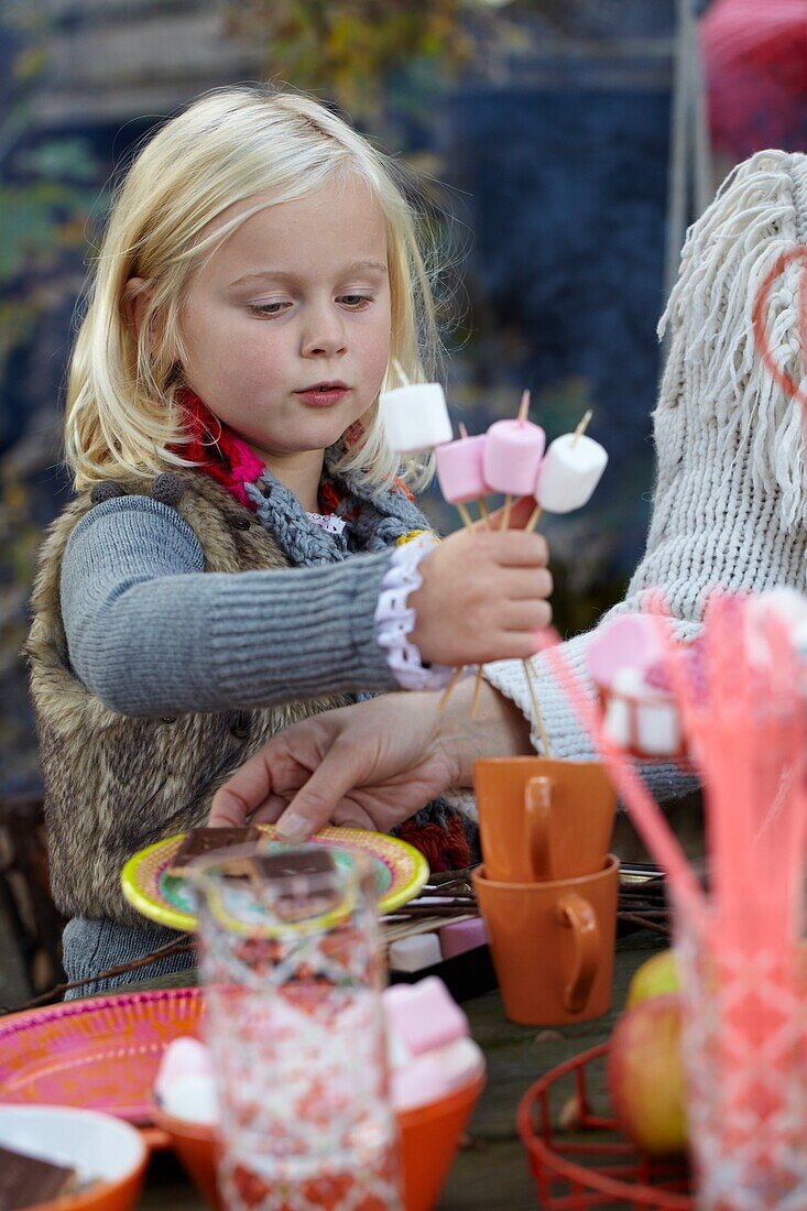 Girl with marshmallow skewers