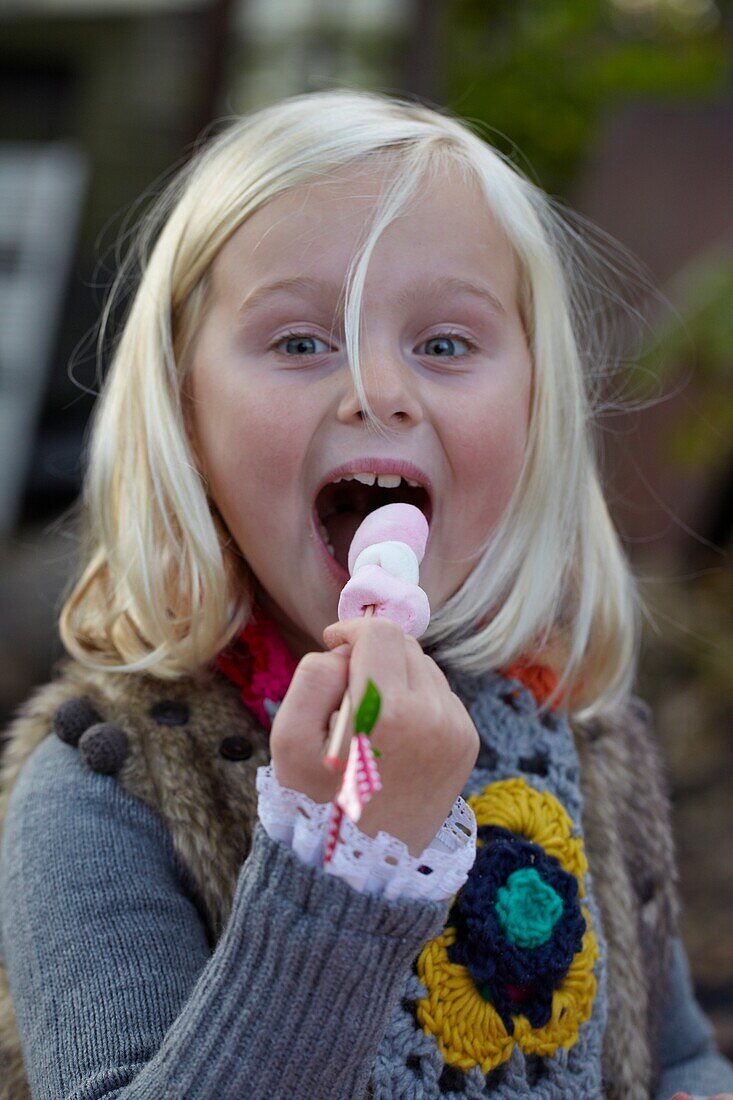 Girl eating marshmallow skewer