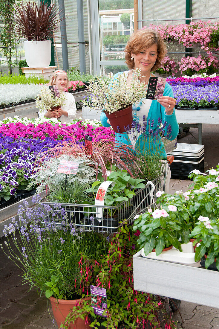 Woman buying plants in garden center