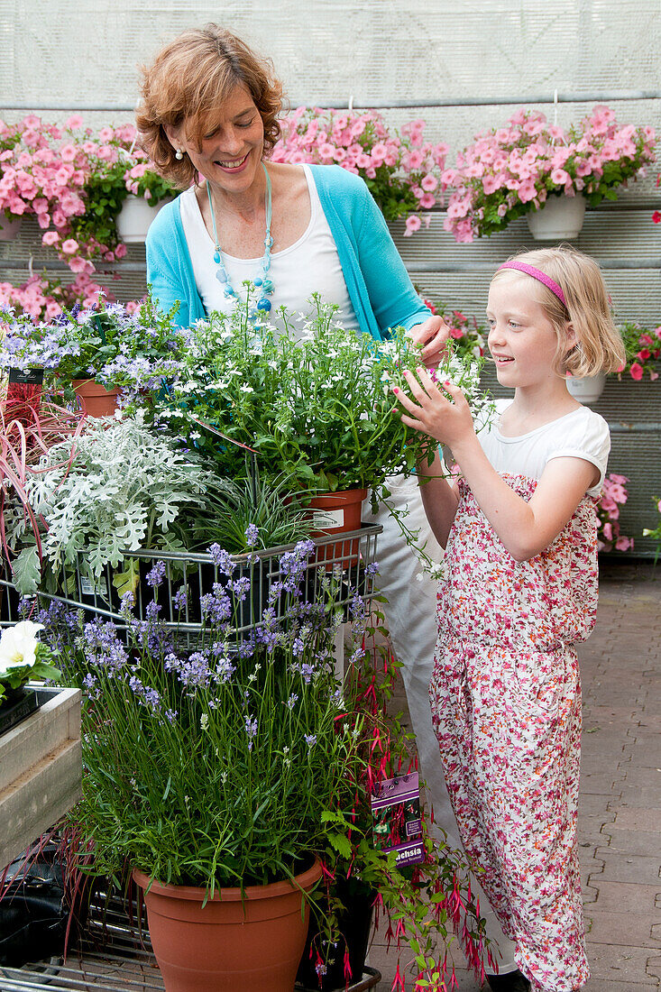 Woman buying plants in garden center