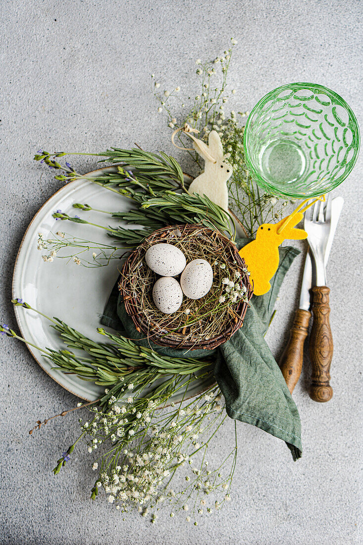 Festliches Oster-Gedeck mit Nest und Eiern