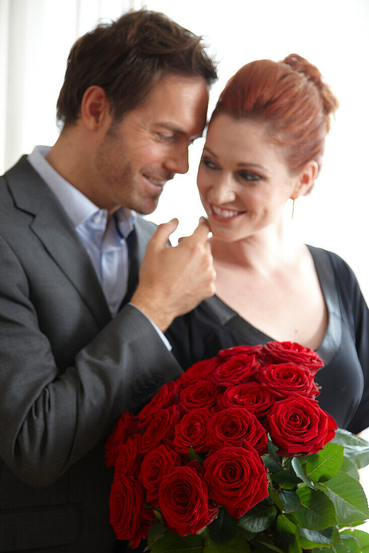 Paar mit roten Rosen in der Hand