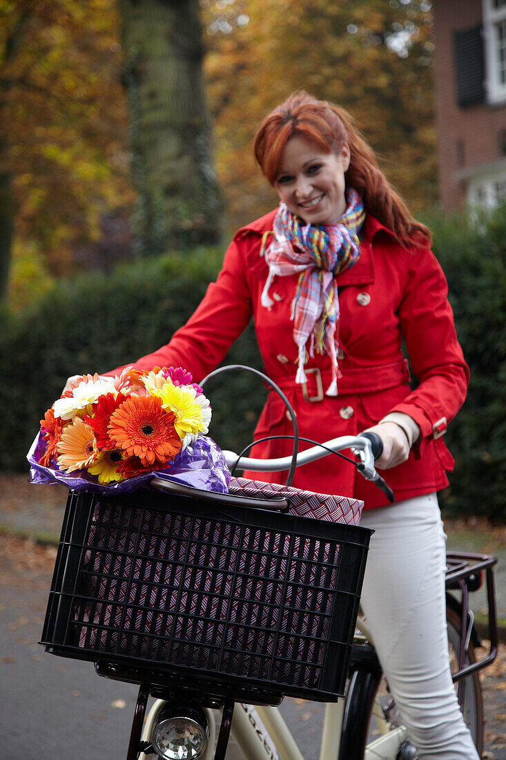 Frau auf dem Fahrrad, Blumen haltend
