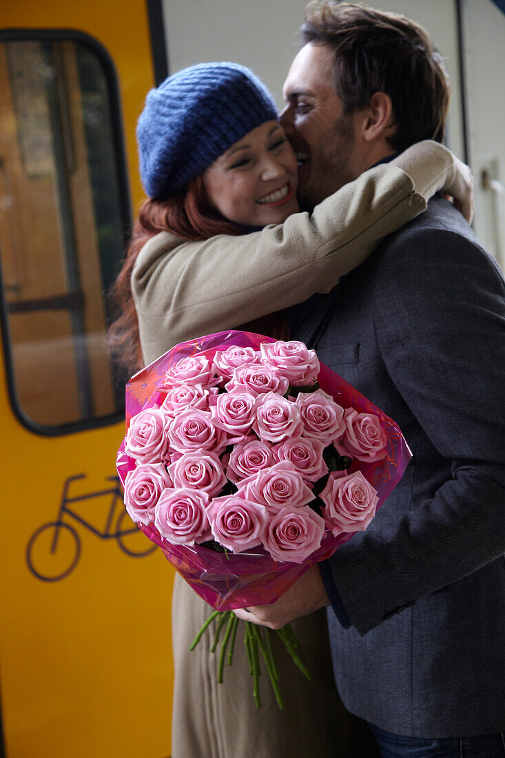 Man welcomes woman with flowers