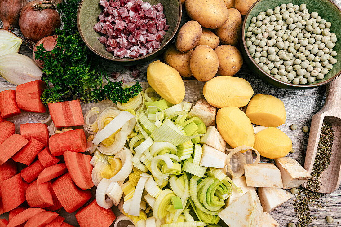 Ingredients for savoury pea stew - bacon, carrots, leek, potatoes, onions, marjoram