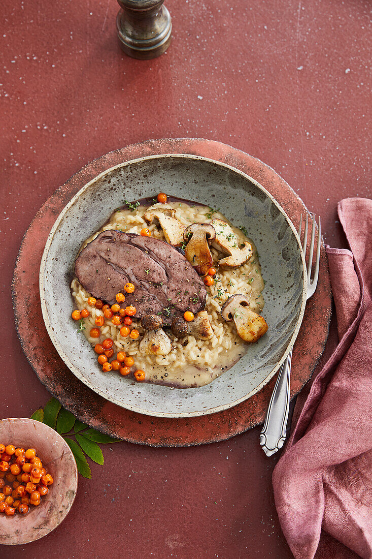 Roast wild boar on porcini mushroom risotto with pickled rowan berries