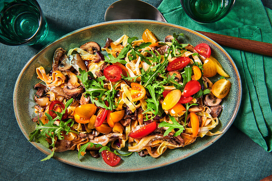 Ribbon noodles with mushrooms, rocket and tomatoes