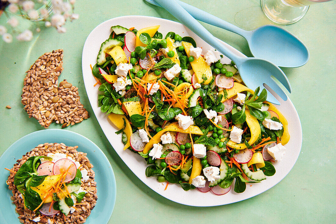 Colourful spring salad with peas, mango and radishes