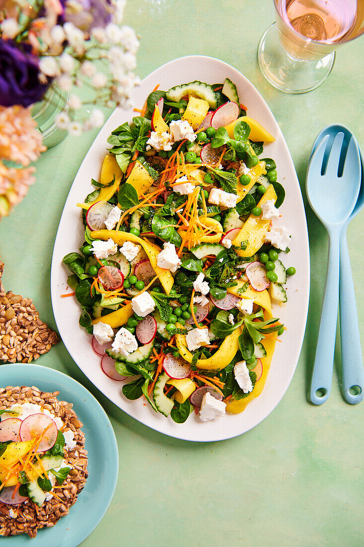 Colourful spring salad with peas, mango and radishes