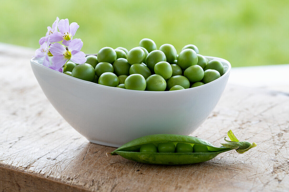 Bowl of fresh peas on a wooden table