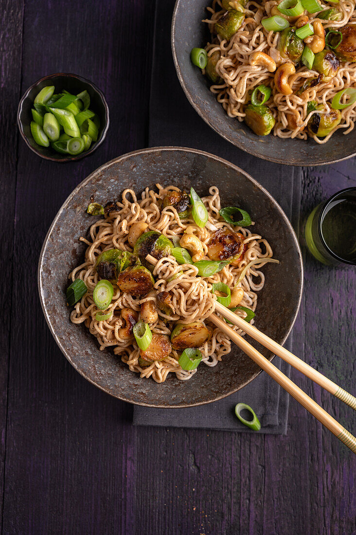 Asian pan with noodles, Brussels sprouts, cashews and spring onions