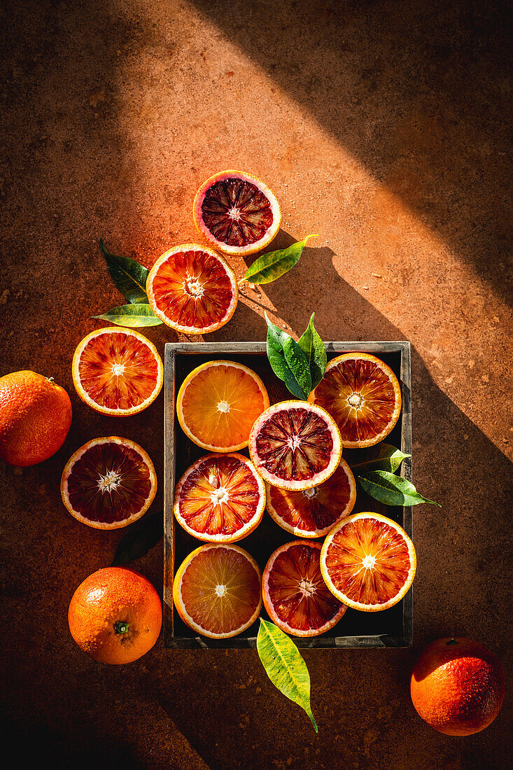 Halved blood oranges with leaves