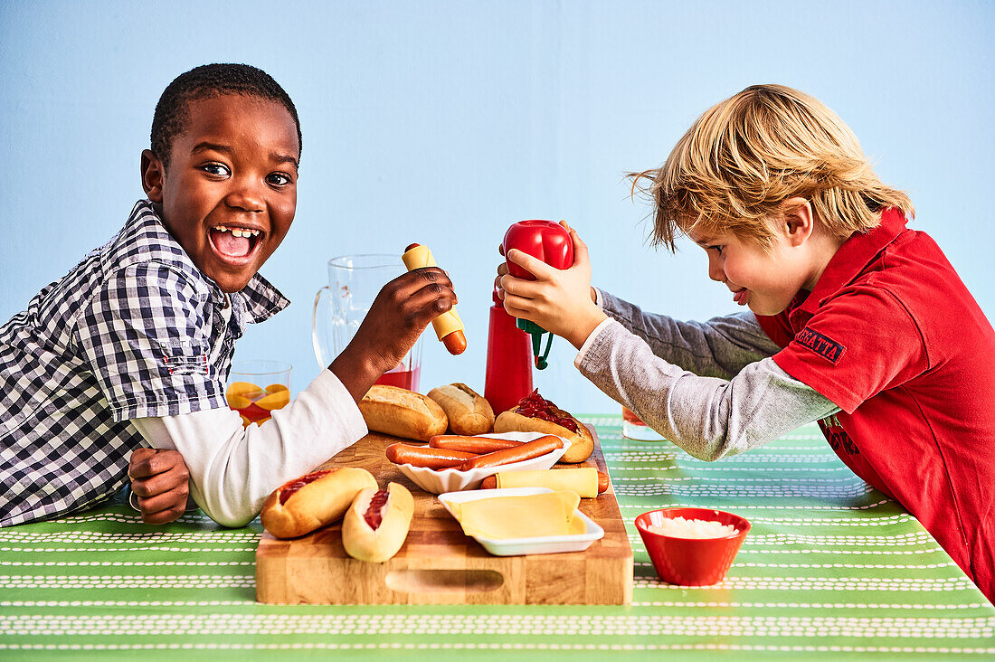 Two boys prepare hot dogs