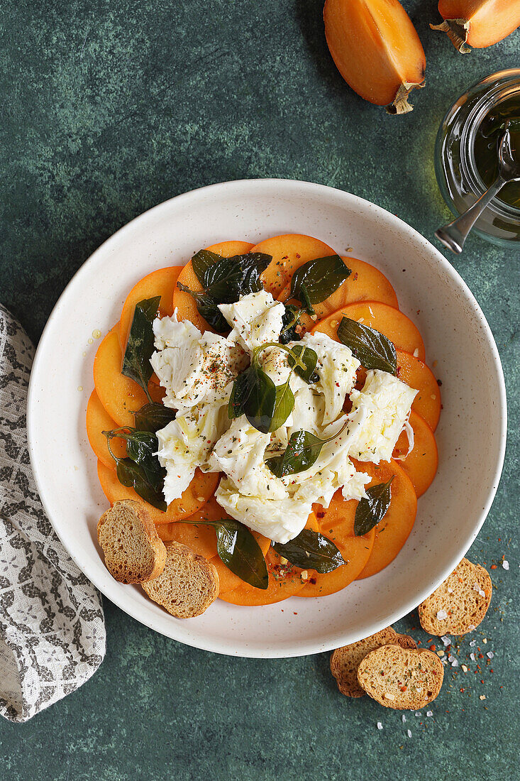 Persimon Caprese Salat mit Mozzarella und Basilikumöl